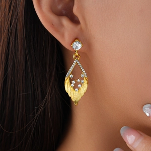 Elegant gold-plated hollow leaf earrings with sparkling crystals shown on a model
