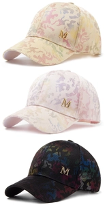 Detail view of mesh baseball caps with camo prints and gold M emblem in three colors