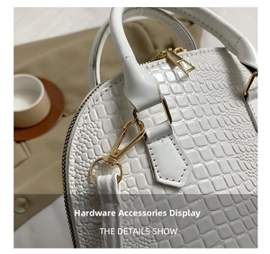 Detailed close-up of white crocodile texture leather and golden metal hardware accessories