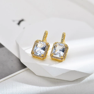 Elegant gold drop earrings with large rectangular white zircon and pave diamond accents