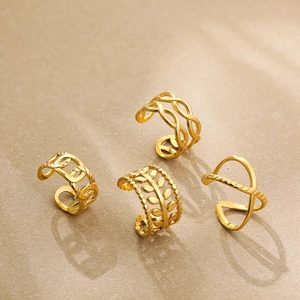 Detailed view of four different gold-plated ear cuffs with leaf and braided patterns