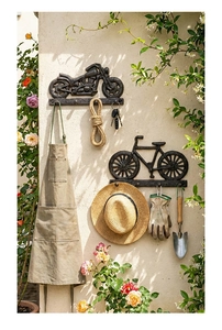 Detalle de ganchos de pared vintage de hierro fundido para moto y bici con accesorios