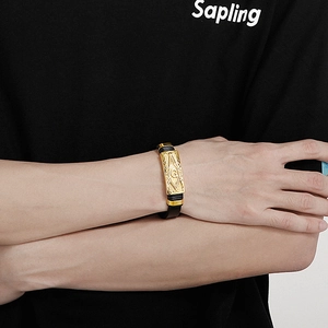 Gros plan du bracelet en cuir pour homme avec symbole maçonnique doré au poignet