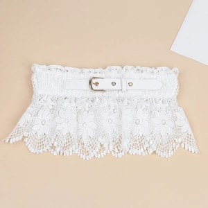 Macro shot of white lace corset belt featuring floral embroidery and gold metal buckle