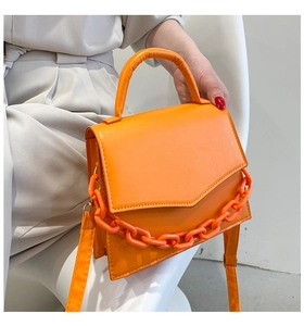Detail of orange PU leather handbag with decorative thick resin chain link detail