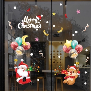 Close-up of festive Christmas window stickers featuring Santa Claus and reindeer on glass