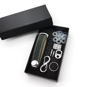 Unboxing detail of a dark green leather key organizer set in a premium black gift box