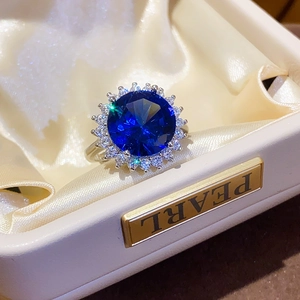 Macro shot of a sunflower halo ring with deep blue sapphire zircon in a beige jewelry box