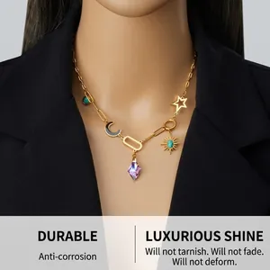 Dettaglio della collana dorata con cristallo viola e ciondoli a stella e luna