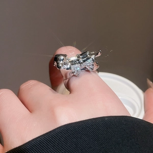 Detail of silver puppy ring with bow tie and diamonds on woman's finger