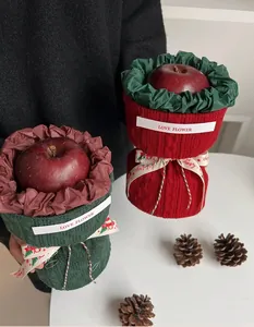 Detail of Christmas knitted gift bags in green and red with festive ribbon and labels