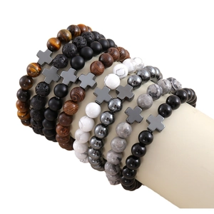 Natural stone and volcanic rock beaded bracelets with cross charms on a wrist