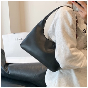 Mirror selfie showing the small black faux leather underarm hobo bag on a model