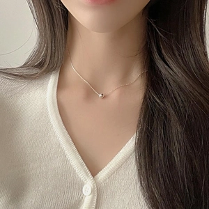 Close-up of 8mm polished 925 sterling silver bead necklace on a model's collarbone