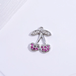 Macro view of cherry pendant with pink and clear crystals on a silver metal base
