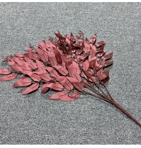 Close-up of red artificial willow leaves bouquet on grey fabric for wedding decor