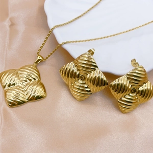 Golden shell pearl jewelry set with spiral texture necklace and earrings on silk