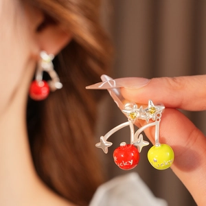 Close-up of cherry-shaped earrings with Lucky engraving, silver stars and zircon stones
