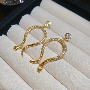 Macro shot of 14k gold plated snake earrings with shimmering pavé zircon stones