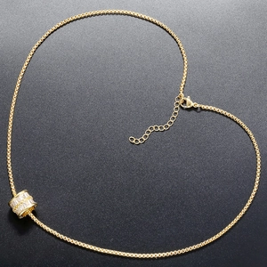 Vue macro d'un pendentif cylindre en plaqué or 18K avec zircons disposés en cœur