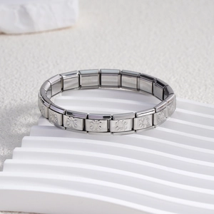Close-up of stainless steel Italian charm bracelet with embossed floral cross patterns