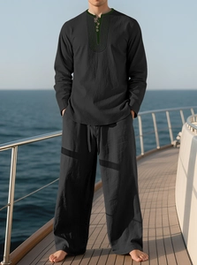 Detail of black linen men's beach set featuring a henley collar on a yacht deck
