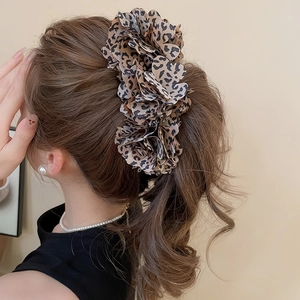 Detailed view of the layered leopard print fabric flower hair claw clip on a ponytail