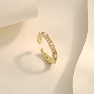 Macro view of gold wave open ring with faux pearls and micro-pave crystals