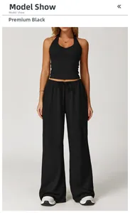 Premium black two-piece yoga set featuring halter neck top and high waist wide leg pants