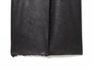 Close-up of black faux fur lining and matte leather texture on a winter long coat