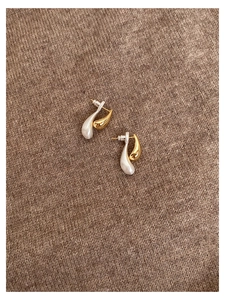 Detail of two-tone teardrop S925 silver earrings with gold and silver split design