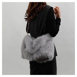 Close-up of grey faux fur tote bag with golden metal chain strap on a model shoulder