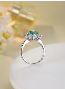 Macro view of 925 silver ring with green emerald-cut gemstone and halo pavé settings