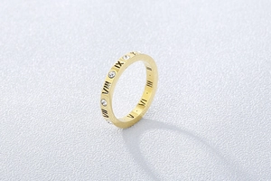 Détail d'une bague en titane plaqué or rose 18 carats avec chiffres romains et cristaux
