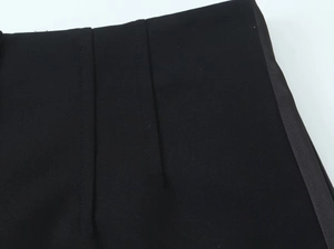 Dettaglio dei pantaloncini neri che mostra il bordo in raso laterale e le cuciture precise
