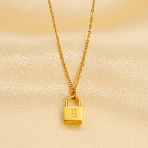 Minimalist gold padlock pendant necklace with gothic letter y on champagne silk fabric