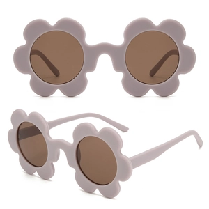 Detail view of purple flower shaped children sunglasses with tinted lenses and petal frame