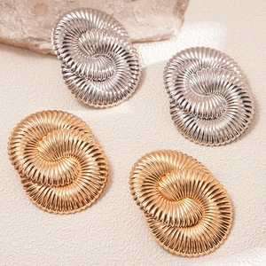 Boucles d'oreilles circulaires en or et argent poli avec texture spirale sur pierre
