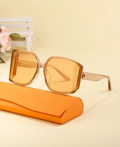 Close-up of orange oversized square sunglasses resting on a matching eyewear case