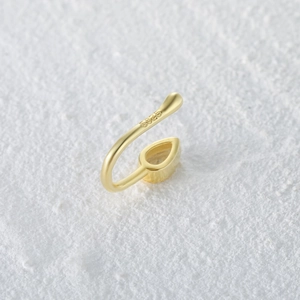 Detailed macro view of S925 sterling silver gold-plated nose cuff with teardrop crystal