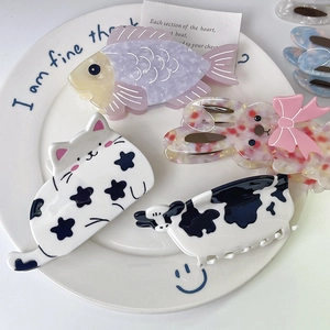 Cute animal acetate hair claws with cat, dog, and cow patterns on a decorative plate