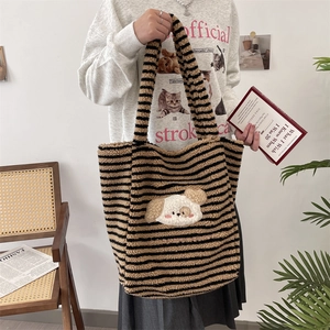 Close-up of fluffy striped tote bag with a cute 3D cartoon dog patch and wide shoulder strap