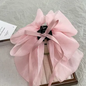 Detail of soft pink chiffon bow hair claw clip with delicate translucent texture