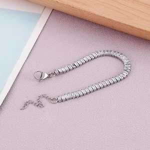 Détail du bracelet en acier argenté avec zircons rectangulaires et chaîne d'extension