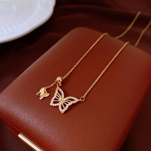 Detail of gold double butterfly necklace with sparkling crystals on leather jewelry box