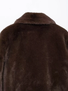 Macro detail of plush faux fur texture and collar on a warm dark brown coat