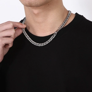Détail d'un collier à maille gourmette en acier titane argenté porté par un modèle