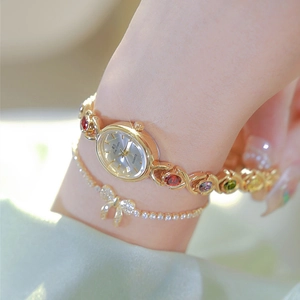 Luxe gold quartz watch with colorful gemstones and a sparkling bow bracelet set