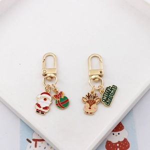 Christmas keychains featuring enamel Santa Claus and reindeer icons with gold hooks