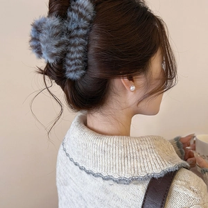 Chic striped plush hair claw clip for women styled on a minimalist bun hairstyle
